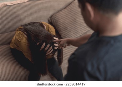 An abusive and manipulative husband points at his emotionally battered wife, making threats and insults. Example of emotional and verbal abuse, or gaslighting.