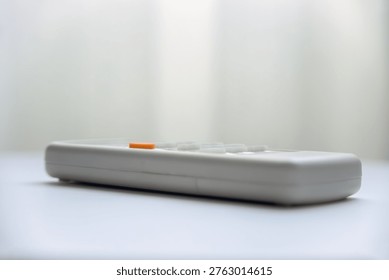 AC remote control on table in living room with copy space background.