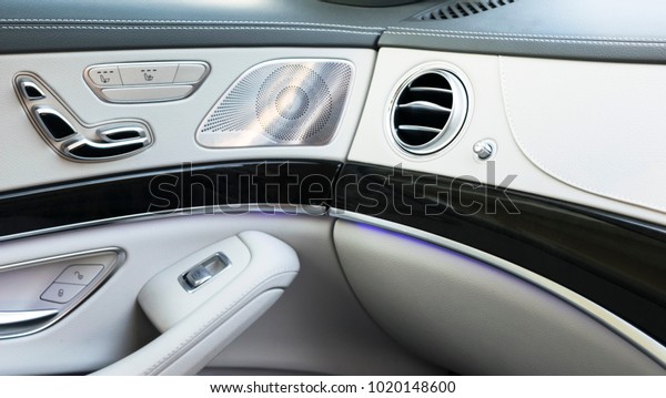 AC Ventilation Deck Luxury Car\
Interior. Door handle with Power seat contol buttons of a luxury\
passenger car. White leather interior of the luxury modern\
car.