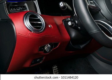 AC Ventilation Deck In Luxury Modern Car Interior. Modern Car Interior Details With Red And Black Leather With Red Stitching. Carbon Panel. Perforated Leather Steering Wheel