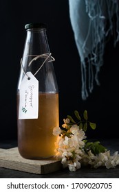 Acacia Syrup In A Bottle, With Acacia Flower. Dark Background.