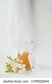 Acacia Syrup In A Jug, White Background. Acacia Flowers.