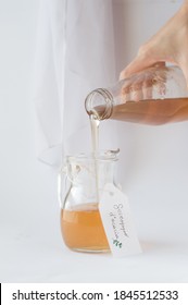 Acacia Syrup, White Background. Female Hand With A Bottle Full Of Syrup.