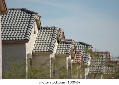 Acacia Trees Frame Track Houses Lined Up In A Desert Southwest Neighborhood.