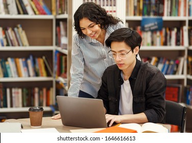 Academic Advisor. Female Brazilian Counselor Monitoring Work Of Korean Architect Student Who Using Laptop In Library