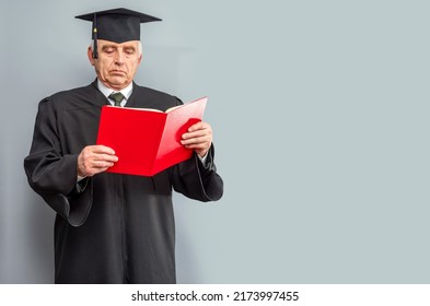 Academician, Professor, Prof Is Wearing A Cap With Tassel And Black Gown. Senior Educator Holding Red Folder. Doctor Of Philosophy, Learned Man From A University Or College.