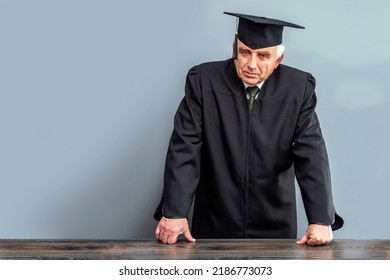 Academician, Professor, Prof Is Wearing A Cap With Tassel And Black Gown. Senior Educator Or Doctor Of Philosophy, Learned Man From A University Or College.