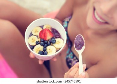 Acai Bowl - Girl Eating Healthy Food On Beach. Woman Enjoying Acai Bowls Made From Acai Berries And Fruits Outdoors On Beach For Breakfast. Girl On Hawaii Eating Local Hawaiian Dish.