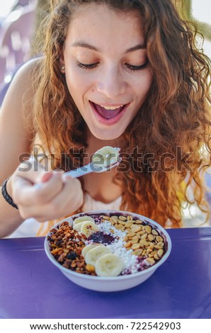 Acai bowl woman eating morning breakfast at cafe. Closeup of fruit smoothie healthy diet for weight loss with berries and oatmeal. Organic raw vegan healthy food.