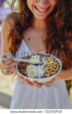 Acai bowl woman eating morning breakfast at cafe. Closeup of fruit smoothie healthy diet for weight loss with berries and oatmeal. Organic raw vegan healthy food.