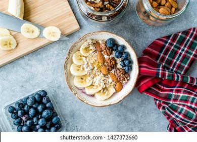 Acai Bowl With Yogurt, Blackberry, Banana Slices, Walnut, Honey, Jam, Oat, Almond, Sesame Seeds And Granola In Porcelain Bowl.