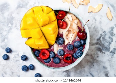 Acai Breakfast Superfoods Smoothie Bowl With Mango, Blueberry, Cherry, Coconut Flakes. Overhead, Top View, Flat Lay. 