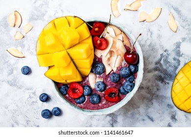 Acai Breakfast Superfoods Smoothie Bowl With Mango, Blueberry, Cherry, Coconut Flakes. Overhead, Top View, Flat Lay. 