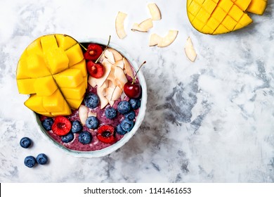 Acai Breakfast Superfoods Smoothie Bowl With Mango, Blueberry, Cherry, Coconut Flakes. Overhead, Top View, Flat Lay. 