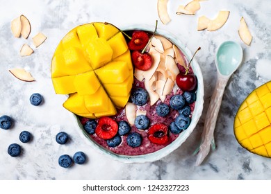 Acai Breakfast Superfoods Smoothie Bowl With Mango, Blueberry, Cherry, Coconut Flakes. Overhead, Top View, Flat Lay. 