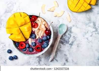 Acai Breakfast Superfoods Smoothie Bowl With Mango, Blueberry, Cherry, Coconut Flakes. Overhead, Top View, Flat Lay. 