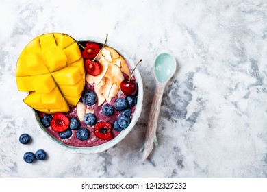 Acai Breakfast Superfoods Smoothie Bowl With Mango, Blueberry, Cherry, Coconut Flakes. Overhead, Top View, Flat Lay. 