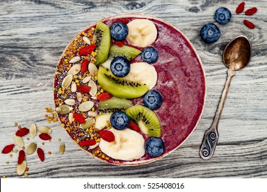 Acai Breakfast Superfoods Smoothies Bowl With Chia Seeds, Bee Pollen, Goji Berry Toppings And Fruits. Overhead, Top View, Flat Lay.