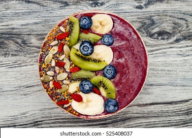 Acai Breakfast Superfoods Smoothies Bowl With Chia Seeds, Bee Pollen, Goji Berry Toppings And Fruits. Overhead, Top View, Flat Lay.