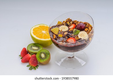 Acai With Granola And Fruits Like Strawberry, Grape, Banana, Papaya, Orange, Kiwi In A Glass Bowl On A White Background. Healthy Food.