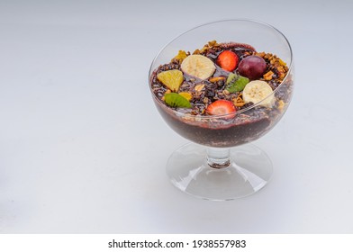 Acai With Granola And Fruits Like Strawberry, Grape, Banana, Papaya, Orange, Kiwi In A Glass Bowl On A White Background. Healthy Food.