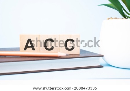 acc concept. search engine optimization acronym on building blocks supported by two different size pencils. Copy space.