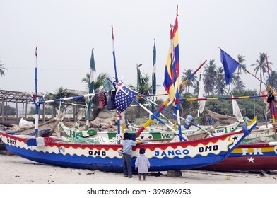 ACCARA, GHANA - JANUARY 07, 2016: Poor Fishermen Prepare Boats For An Exit To The Ocean. Children Watch Preparation Of Fishing Nets. In 1957 Ghana  Declare Independence From European Colonization.