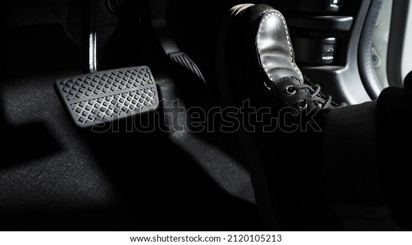 Accelerate and Brake. Foot pressing foot pedal\
of a car to drive ahead. Accelerator and brake pedal in a car.\
Driver driving the car by pushing accelerator pedals of the car.\
inside vehicle\
automobile