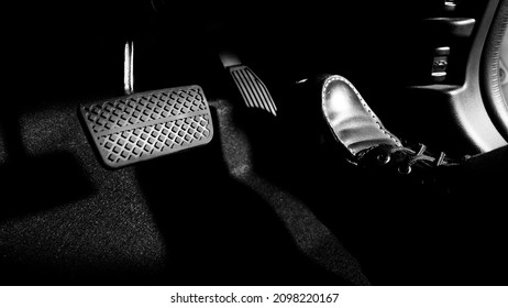 Accelerator and breaking pedal in a car. Close up the foot pressing foot pedal of a car to drive ahead. Driver driving the car by pushing accelerator pedals of the car. inside vehicle.