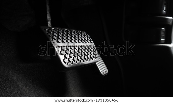 Accelerator and breaking pedal in a car. Close up the
foot pressing foot pedal of a car to drive ahead. Driver driving
the car by pushing accelerator pedals of the car. inside vehicle.

