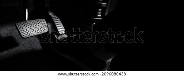 Accelerator and breaking pedal in a car. Close\
up the foot pressing foot pedal of a car to drive ahead. Driver\
driving the car by pushing accelerator pedals of the car. Foot\
pedals inside\
vehicle.