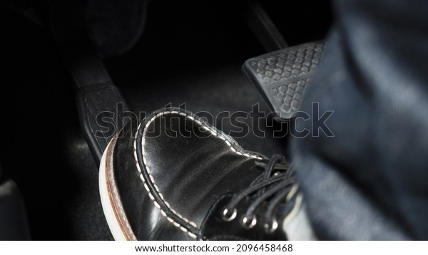 Accelerator and breaking pedal in a car. Close\
up the foot pressing foot pedal of a car to drive ahead. Driver\
driving the car by pushing accelerator pedals of the car. inside\
vehicle.