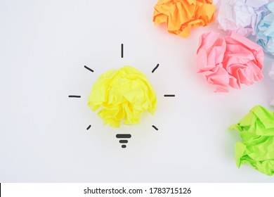 Accept creative idea, be different, solution concept. Come up with a creative idea. Crumpled paper symbolizing various solutions with one highlighted as a light bulb as the correct one.