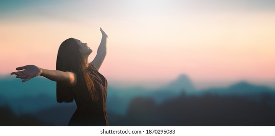 Acceptance concept: Happy girl raised hand on blurred mountain sunrise background. Phang-nga, Thailand, Asia - Shutterstock ID 1870295083