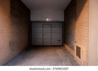 Acceso a un garaje en un edificio residencial con vehículos estacionados
