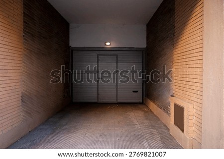 Acceso a un garaje en un edificio residencial con vehículos estacionados