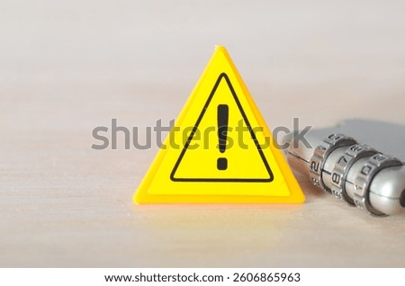 Access Control Alert: Yellow Warning Sign with Secure Combination Lock