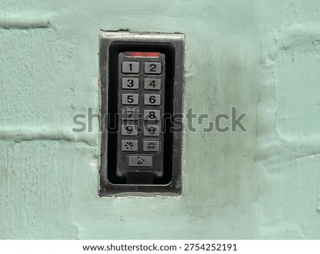 An access keypad embedded in the wall to secure entry for residents of an apartment building.