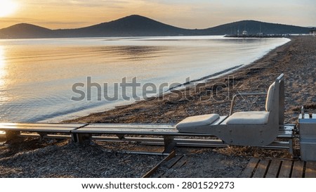 Accessible beach with sea access system for people with disabilities at sunrise in Greece. Inclusive tourism and barrier-free recreation, wheelchair-friendly public facility on Greek coast