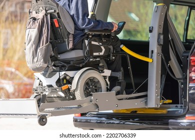 Accessible car with wheelchair lift ramp for person with disability.