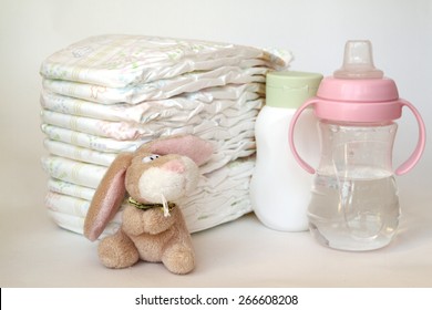 accessories for baby diapers on white background, banny, a bottle of water, cream