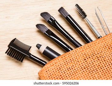 Accessories for care of brows. Brow comb, eyebrow pencil, angled brushes, tweezers, spooly brush in cosmetic bag. Eyebrow grooming tools