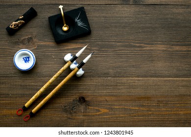 Accessories For Chinese Or Japanese Calligraphy. Special Writting Pen, Ink On Dark Wooden Background Top View Space For Text