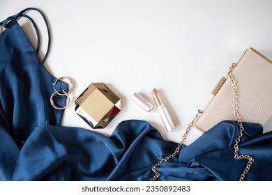 Women’s accessories, handbag and cocktail dress in blue are on a light background. Copy space. - Shutterstock ID 2350892483