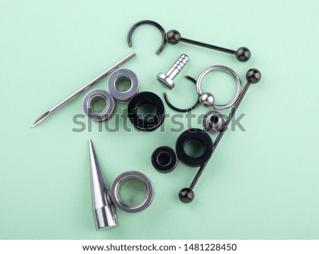 accessories for piercing on a mint background close-up