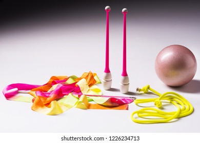 Accessories For Rhythmic Gymnastics Ball, Clubs, Ribbon, Rope Lie On The Floor. White Background