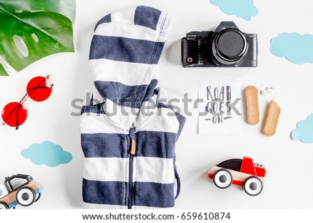 accessories for treveling with children, camera and suit on white background top view