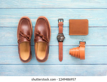 Men’s Accessory With Loafer Shoe, Wallet Leather, Brown Watch And Belt  Isolated On A Blue Wooden Background. Top View.