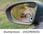 Accident between a car and a cyclist presented with bicycle in the rearview mirror