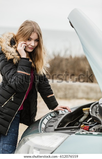 Accident\
and breakdowns with auto concept. Broken down car, blonde woman\
having problem, calling to somebody for\
help.